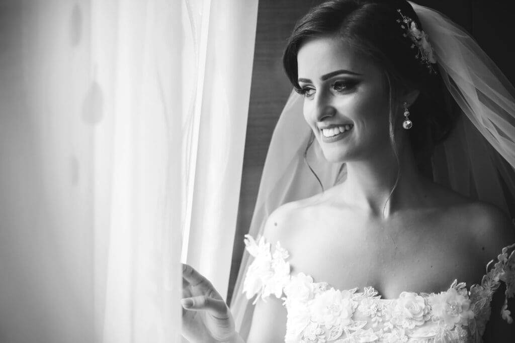 A bride trying on an elegant lace wedding dress, surrounded by her bridesmaids
